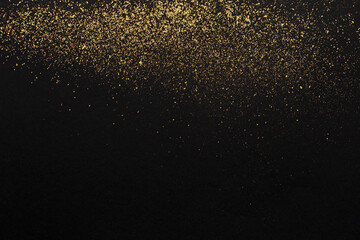 Fototapeta na wymiar Gold glitter on black background. Holiday abstract texture