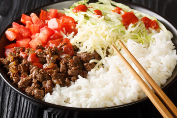 Takoraisu Taco rice is a Japanese dish hailing from Okinawa close-up in a bowl on the table....