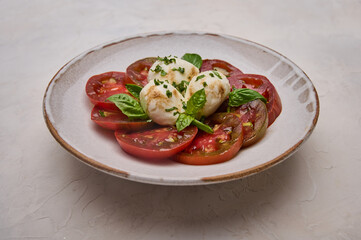 Delicious caprese salad in ceramic light plate. Close up 