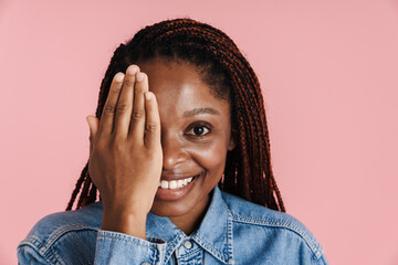 Young black woman with afro pigtails smiling and covering her eye