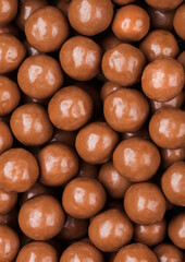Round crunchy milk chocolate candies to use as background.