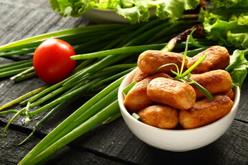 Tasty appetizer, spicy cocktail sausages with salads.