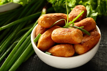 Bowl of spicy cocktail sausages and salads.