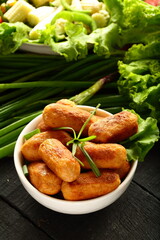 Delicious homemade cocktail sausages with fresh greens,