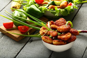 Delicious appetizers background- homemade spicy and crispy nuggets with salads.
