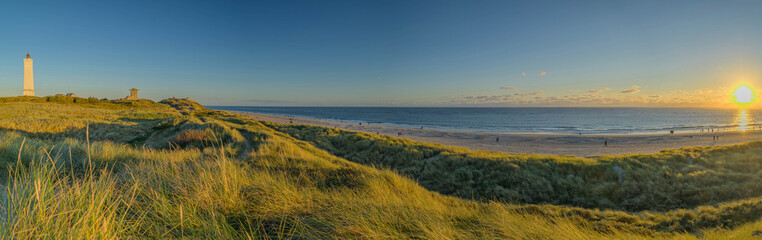  Sunset over dunes. Panoramic view of Blåvand lighthouse on wide dune of Blåvandshuk with beach view on the west coast of Jutland, by Esbjerg, Denmark.  - obrazy, fototapety, plakaty