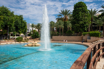 Fountains and palms in city garden park in Israel, Rishon Lezion. Summer landscape