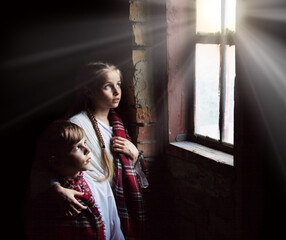 Small girl praying at the window