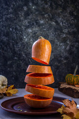 Levitation pumpkin on a background of seeds and autumn leaves. Simple composition, rustic style