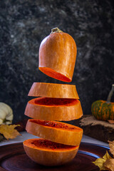Levitation pumpkin on a background of seeds and autumn leaves. Simple composition, rustic style