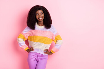 Photo of adorable dark skin lady put arms on waist look empty space beaming smile isolated on pink...