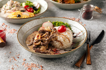 Beef stroganov with mushrooms and rice in a plate