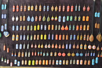 Colorful ancient decorative earrings hanging  on a dark wall. Antique jewelries. Uzbekistan's accessories.