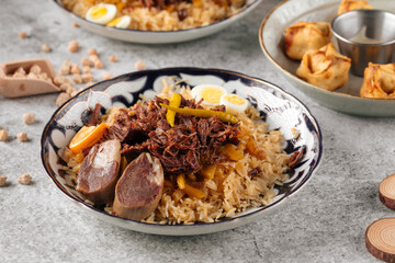 Uzbek national dish pilaf plov with rice and meat on gray background