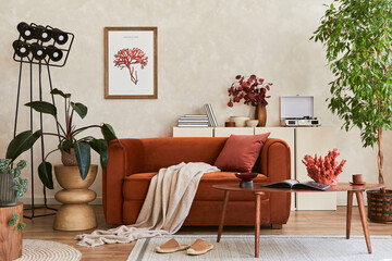 Creative composition of stylish living room interior with mock up poster frame, orange sofa, beige commode, coffee table and stylish personal accessories. Artistic space. Template.