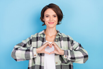 Photo of flirty millennial brunette lady show heart wear plaid shirt isolated on blue color...