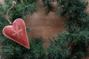 Christmas decoration heart on the green fir branches. Christmas time background.