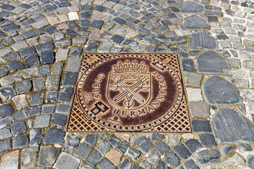 A manhole cover with coat of arms of Sibiu in Romania