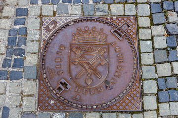 A manhole cover with coat of arms of Sibiu in Romania