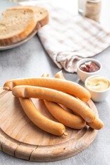 Smoked frankfurter sausages on cutting board.