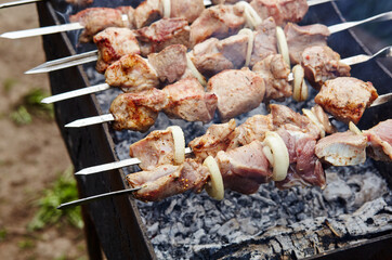 Marinated shashlik preparing on a barbecue grill over charcoal. Traditional Russian shashlik on a barbecue skewer