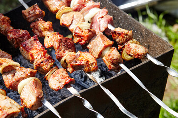 Marinated shashlik preparing on a barbecue grill over charcoal. Traditional Russian shashlik on a barbecue skewer
