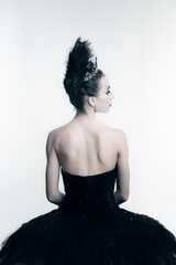 Back view of young ballerina wearing black tutu, stage dress posing isolated on white studio...
