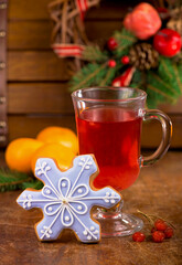 a cup of tea with spices and viburnum berries and Christmas gingerbread with a wreath of evergreen branches