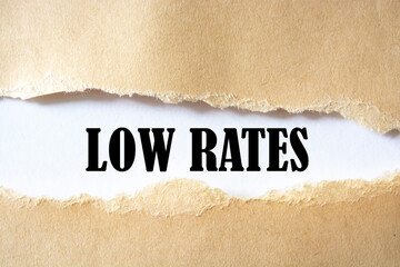 LOW RATES. words. text on brown paper on torn paper background.