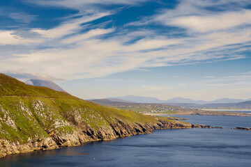 View on amazing Keem bay from a top of a mountain. Warm sunny day. White clouds on blue sky....