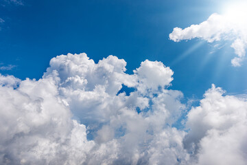 Naklejka na ściany i meble Beautiful blue sky with white cumulus clouds and sun rays (sunbeams). Backlight photography. 