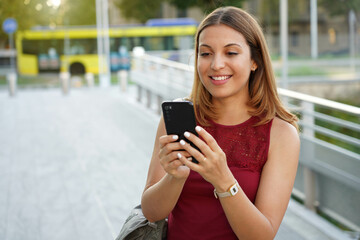 Fototapeta na wymiar Attractive girl using phone outdoors