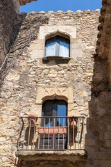 old facade in pals of a stone tower with a window and a balcony