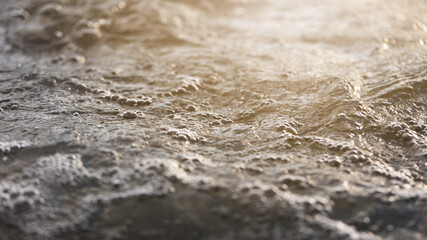 Background of floating ocean with shining sunlight. Wallpaper of sea with bubbles on surface in sunlit. Splashing waves with space for text.