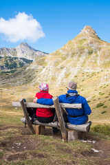 Fototapeta premium Couple sitting on a bench. National park Durmitor Mouintains in Montenegro. 
