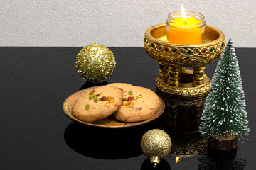 Christmas table decorations with scented candle and a plate of orange peel biscuits.