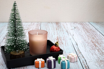 Christmas decorations on a table with a piece of scented candle.
