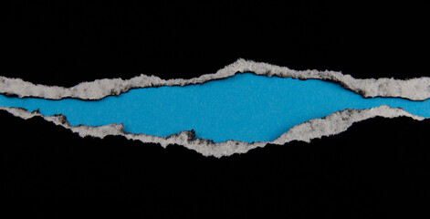 Black paper with torn marks placed on a blue paper background. The top corner image can be used as a background. with copy space and text area