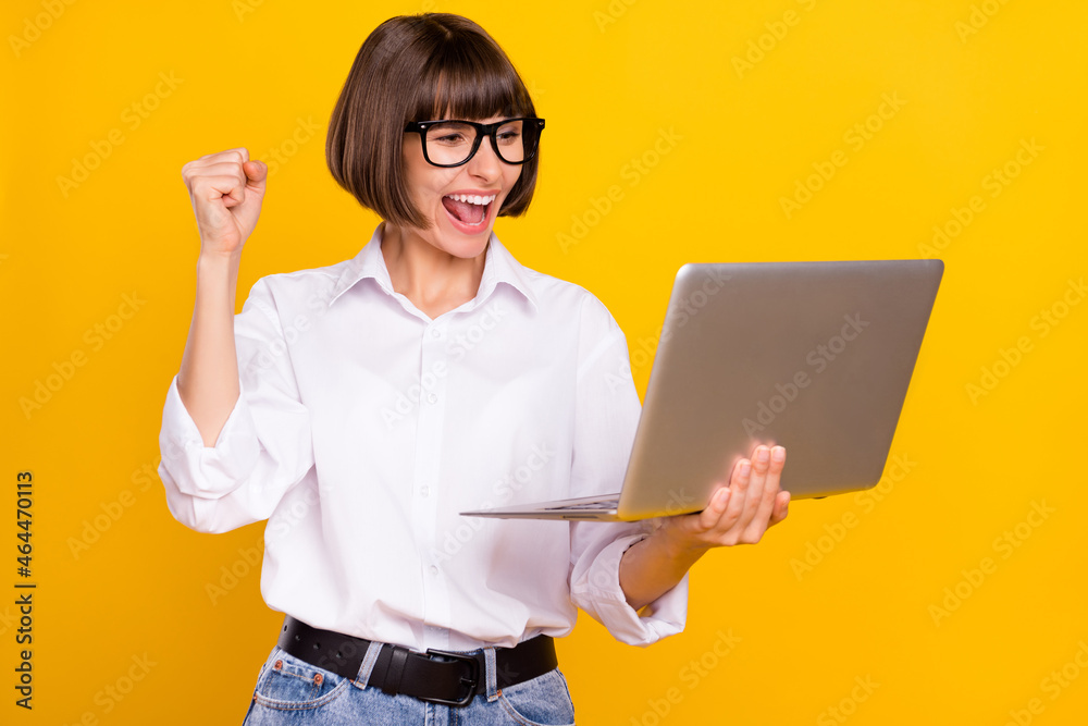 Poster Photo of astonished lady hold netbook scream yes wear eyewear white shirt isolated yellow color background