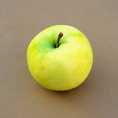 Ripe juicy yellow-green apple on a wood background