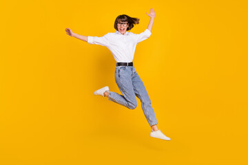 Fototapeta na wymiar Photo of careless lady jump hurry run wear eyeglasses white shirt jeans shoes isolated yellow color background