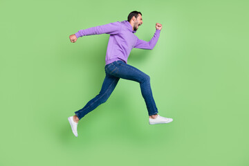 Fototapeta na wymiar Full size profile side photo of young man hurry go walk runner fast isolated over green color background