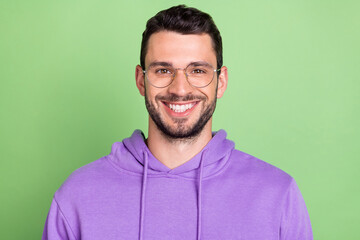 Photo of nice young brunet guy wear eyewear violet hoodie isolated on green color background