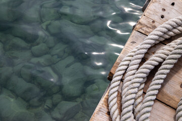 Rolled up white ropes on a boating dock yard in Spain - obrazy, fototapety, plakaty