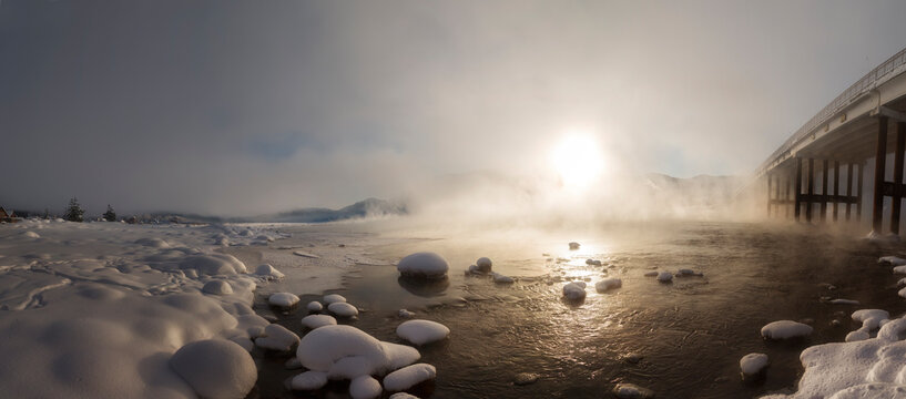 Panorama with Lake Teletskoye and the bridge over the Chuya River at sunrise in winter