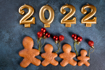 Obraz na płótnie Canvas Homemade gingerbread cookies on dark background. Christmas composition, new year background. Number 2022 with cookies. Christmas dessert. New Year flatlay.