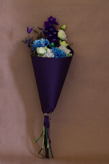 a bouquet of blue and blue flowers in a purple wrapper