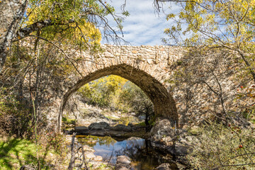 Fototapeta na wymiar Matafrailes medival bridge in a stream that empties into the Lozoya river in the Sierra de Guadarrama, Madrid