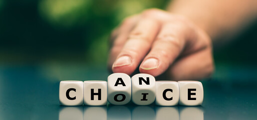 Hand turns dice and changes the word choice to chance. Symbol that every choice is also a chance.