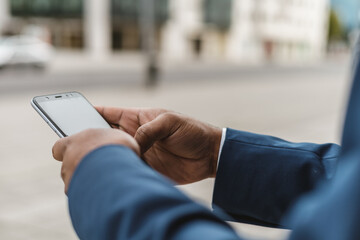 close-up of unrecognizable dark skinned businessman using smartphone